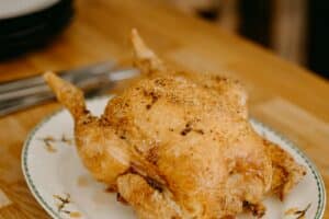 Frango assado dourado em prato branco
